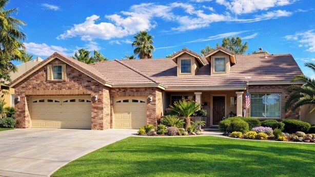Une maison à deux étages avec une façade en briques, un garage à l’avant et une pelouse bien entretenue.