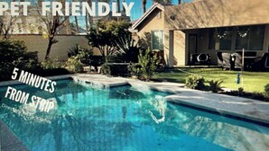 Un cadre résidentiel comprenant une piscine, une pelouse et une maison.