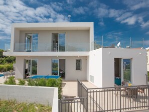 A modern two-story building with large windows, a balcony, and a pool area. - Schöne, topmoderne Ferienvilla auf Zypern by Interhome (Paralimni)