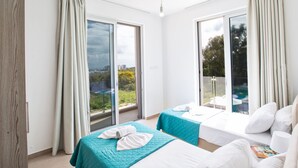 A hotel room with two beds, a balcony, and large windows. - Schöne, topmoderne Ferienvilla auf Zypern by Interhome (Paralimni)