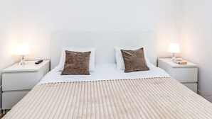 Ett hotellrum med en säng, två sängbord och två lampor.