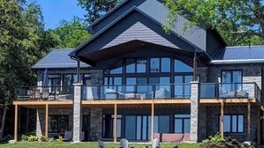A large two-story house with a balcony and outdoor seating area. - Experience Ultimate Luxury at our Exquisite Lakehouse. Large family gatherings! (Erinsville)
