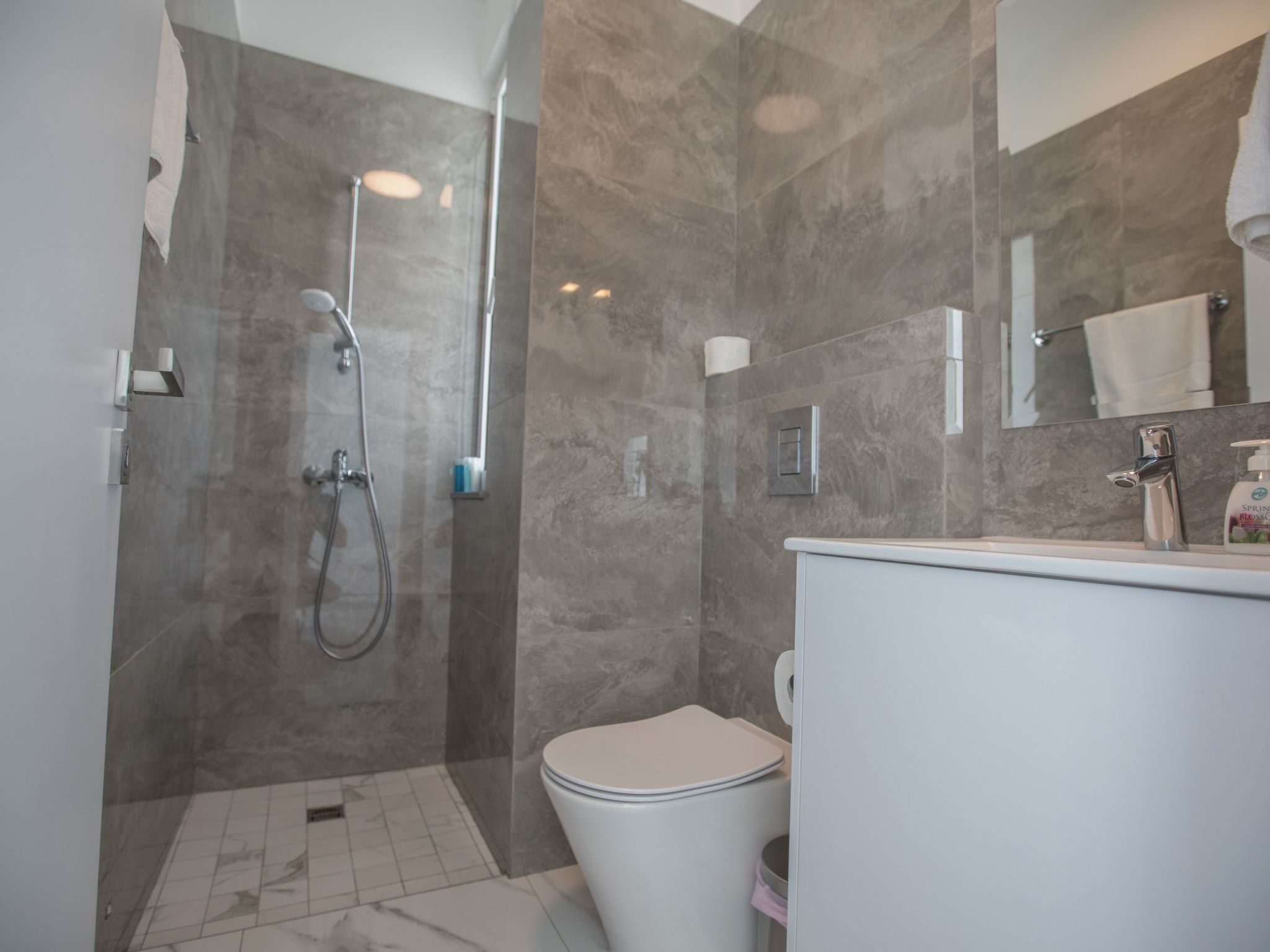 Une salle de bain moderne équipée d’une douche, de toilettes et d’un lavabo.