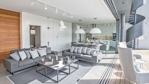 A modern living room with a sectional sofa, a coffee table, and pendant lighting.