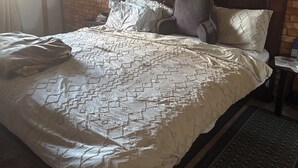 A bedroom with a brick-patterned headboard, a bed with a patterned quilt, and three wall-mounted artworks. - Charming 4-bedroom house perfect for your getaway. Panoramic view from balcony (Guadalupe)