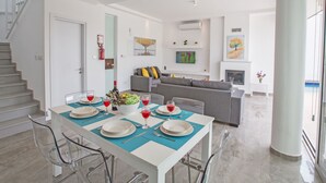 A modern living room with a dining area, a staircase, and a fireplace. - Protaras Villa mit privatem Pool und Dachgarten by Interhome (Protaras)