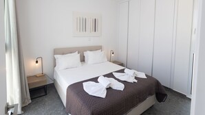 A hotel room with a bed, bedside tables, a wardrobe, and a painting on the wall. - Luxuriöse Villa Vie Bleu by Interhome (Protaras)