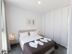 A hotel room with a bed, bedside tables, a wardrobe, and a painting on the wall. - Luxuriöse Villa Vie Bleu by Interhome (Protaras)