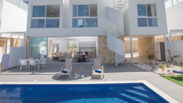 A modern two-story house with a spiral staircase, a pool, and outdoor seating. - Ferienvilla Vie Bleu mit großem Pool by Interhome (Protaras)