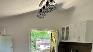 Una cucina moderna con mobili bianchi, un piano di lavoro in legno e un'area pranzo con tavolo e sedie.