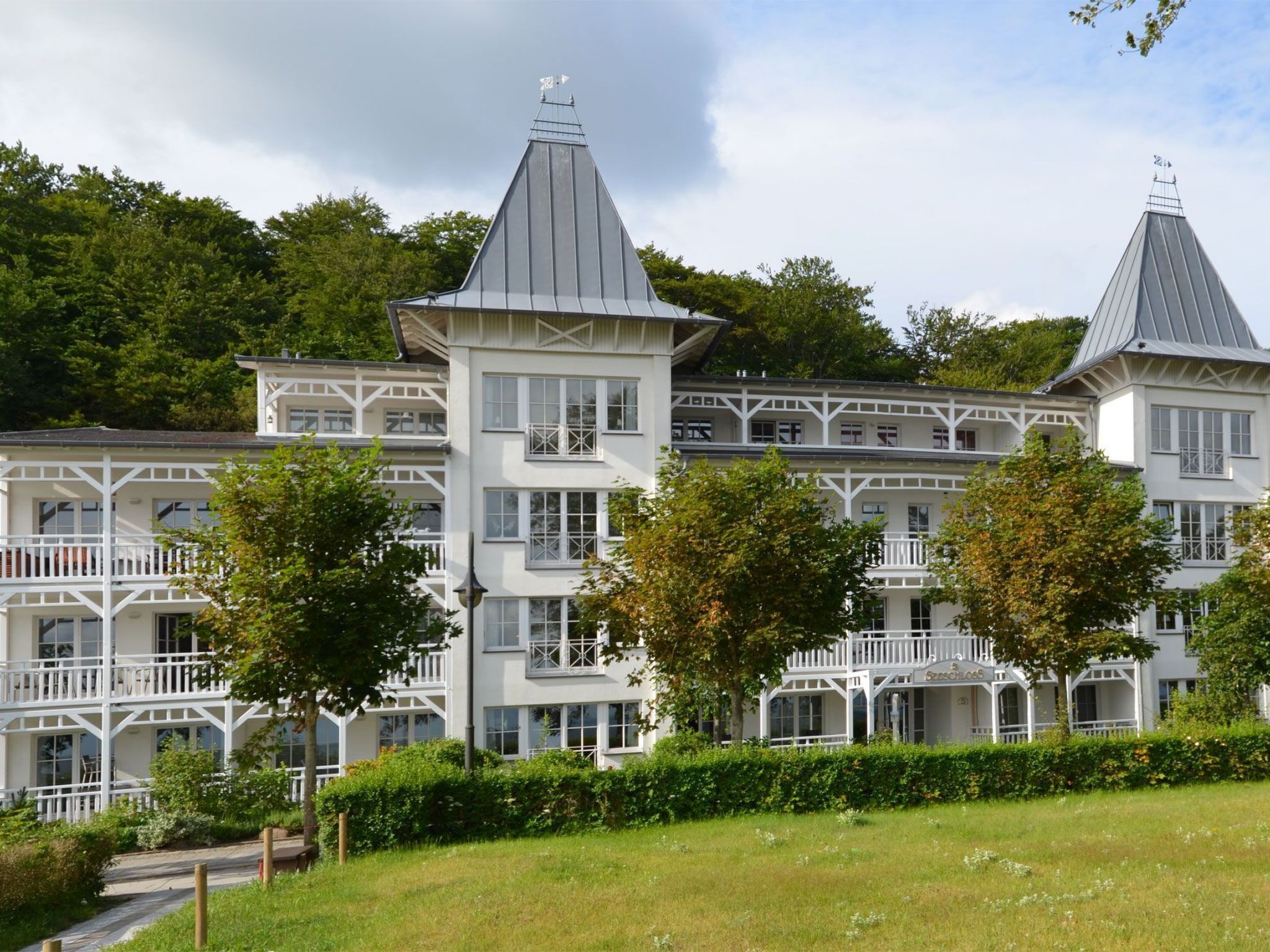 Ein großes, mehrstöckiges Gebäude mit einer symmetrischen Fassade, mehreren Balkonen und einem zentralen Turm.