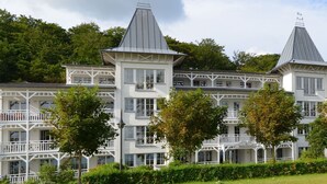 A large, multi-story building with a symmetrical facade, multiple balconies, and a central tower. - Appartement NeunUndZwanzig in Ostseebad Binz by Interhome (Binz)