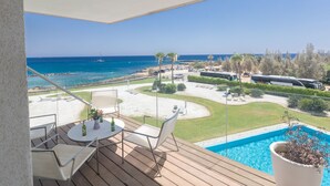 A balcony with a view of the sea, a pool, and a parking area with buses. - Luxuriöse Wohnung am Strand von Thalassa by Interhome (Paralimni)