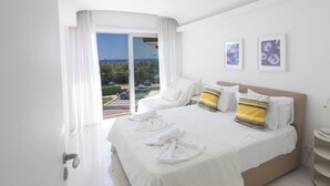 A hotel room with a large bed, a view of the sea, and two framed pictures on the wall. - Luxuriöse Wohnung am Strand von Thalassa by Interhome (Paralimni)