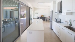 A modern kitchen with white cabinetry, a built-in oven, and a stainless steel sink. - in Ayia Napa mit großem Patio by Interhome (Ayia Napa)