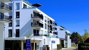 A modern multi-story hotel with balconies, a parking area, and a no parking sign. - Pfänder by Interhome (Friedrichshafen)