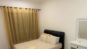 Quarto com uma cama, um ventilador de teto, uma mesinha de cabeceira e um espelho.