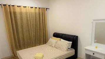 A bedroom with a bed, a ceiling fan, a bedside table, and a mirror.