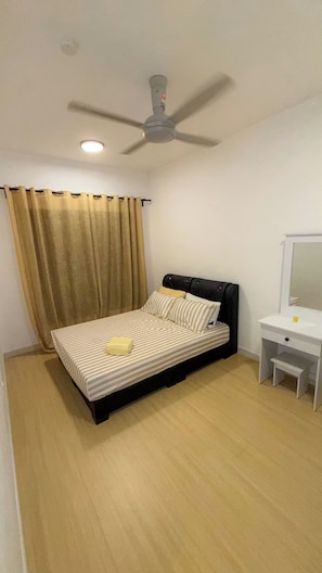 A bedroom with a bed, a ceiling fan, a bedside table, and a mirror.