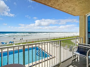 A balcony with a view of a beach and a swimming pool. - Oceania Beach Club 205 (New Smyrna Beach)