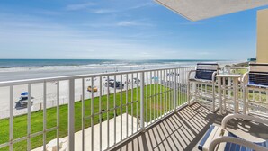 Ein Balkon mit Blick auf Strand und Meer.