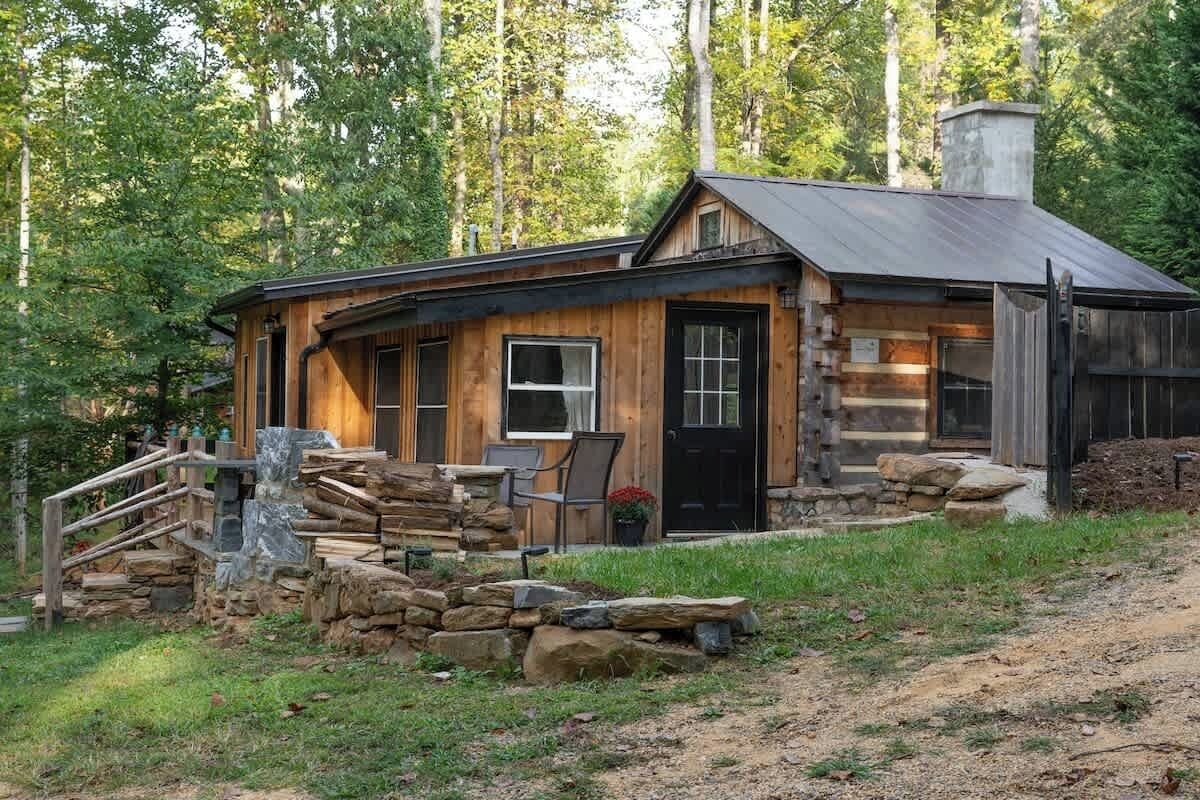 Un chalet rustique avec un escalier en pierre, une terrasse en bois et une cheminée.