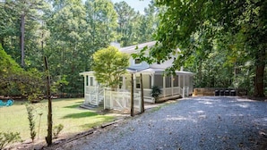 A house with a covered porch, a fenced yard, and a gravel driveway. - Quiet Retreat - Piano, Firepit, Peloton (Pittsboro)