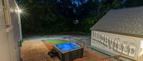Ein Garten mit Whirlpool, Basketballkorb und einem Schild, das "Nashville Music City U.S.A. EST. 1779" zeigt.