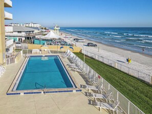 Et hotel med swimmingpool, udsigt til stranden og en redningstårn.