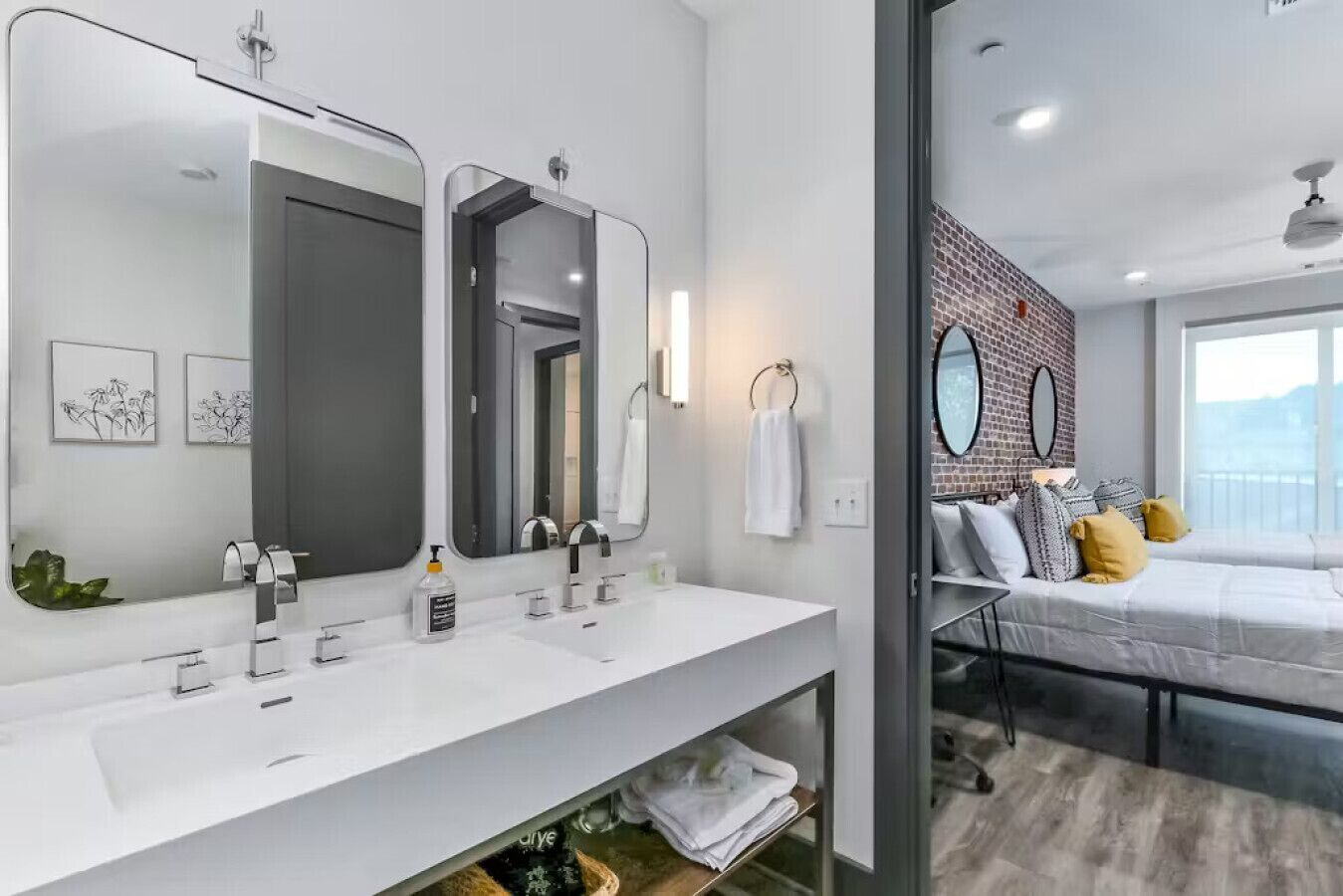 A modern bathroom with dual sinks, a large mirror, and a glass shower enclosure.