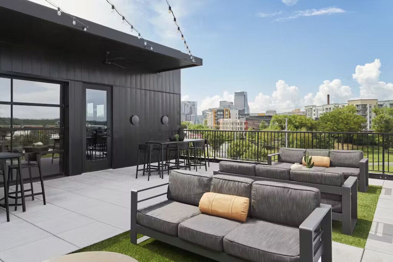 A rooftop terrace with outdoor seating, a dining area, and a city view.