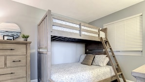 A bunk bed with a ladder, a dresser with drawers, and a window with blinds. - Oceania Beach Club 706 (New Smyrna Beach)
