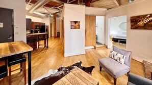 Un'ampia zona giorno con un tavolo da pranzo in legno, un divano e un tappeto in pelle di vacca.