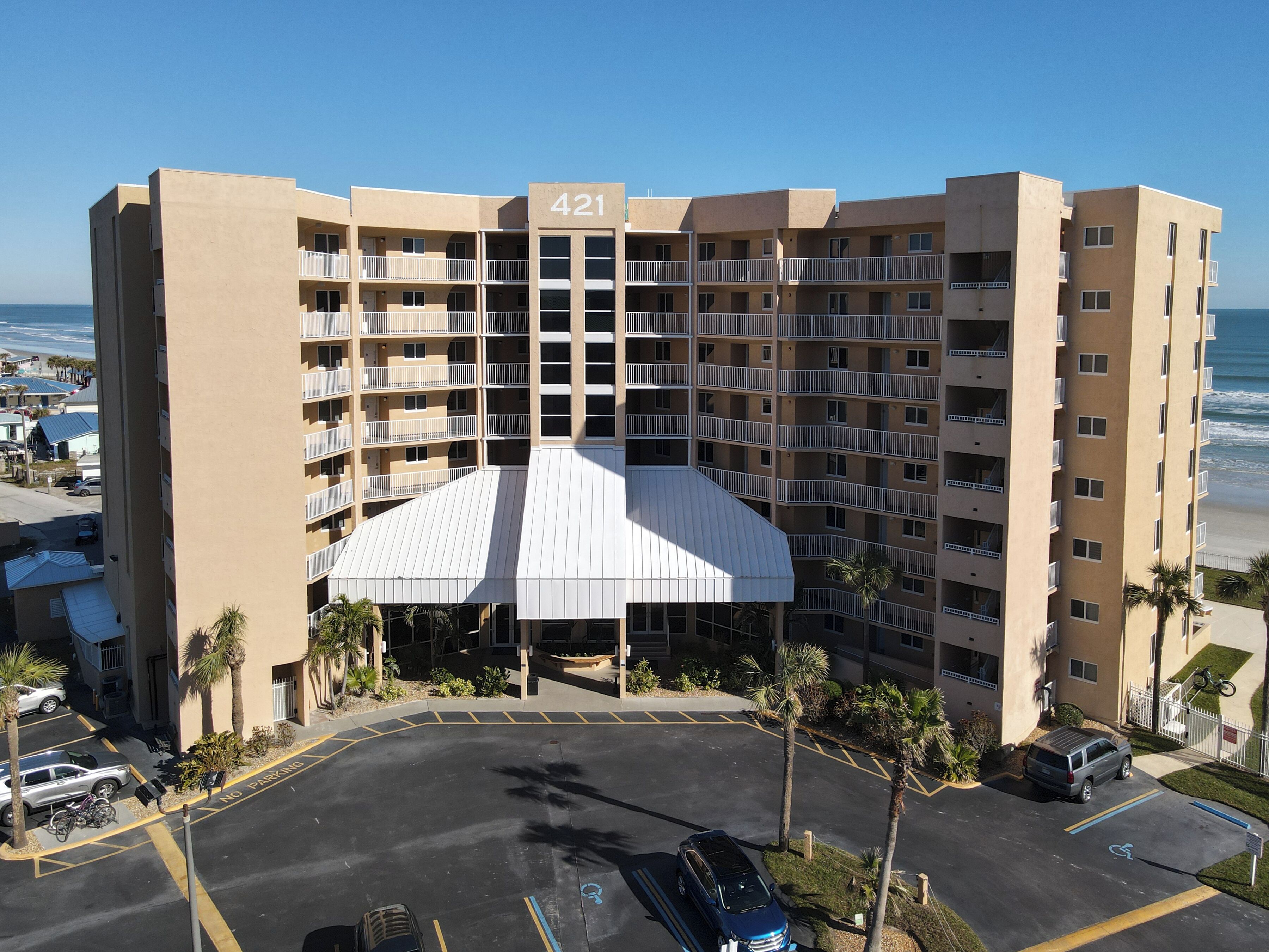 Un hotel de varios pisos con fachada plana, número 421, que presenta un atrio central con techo blanco.