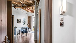 A modern interior with exposed wooden beams, a kitchen area with bar stools, and a dining table. - June (Nashville)