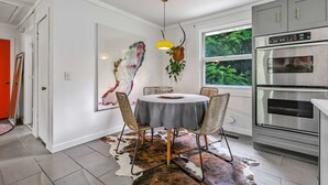 A modern kitchen with a round dining table, a large window, and a built-in oven. - Bachelorette Retreat in Nashville (Nashville)