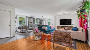 A modern living room with a sofa, chairs, a coffee table, and a TV. - Bachelorette Retreat in Nashville (Nashville)