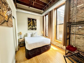 A bedroom with a large bed, a painting on the wall, and a window with curtains. - Willie (Nashville)