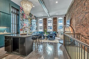 A modern kitchen with a central island, bar stools, and a decorative chandelier. - Bettye - B (Nashville)