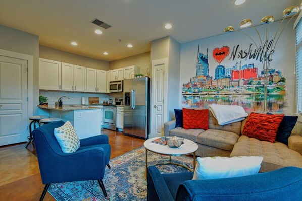 A modern apartment with a kitchen, living room, and a mural of Nashville skyline. - I Love Nashville Near Music Row Free Parking (Nashville)