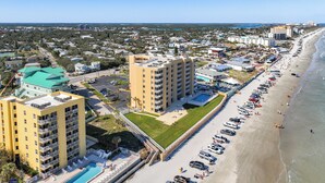 A coastal hotel with multiple floors, a swimming pool, and a beachside location. - Oceania Beach Club 504 (New Smyrna Beach)