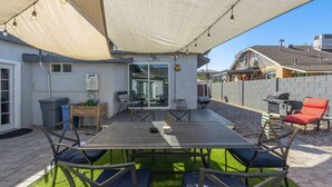 A patio with a table and chairs, a barbecue grill, and a covered seating area. - Central Phoenix Casita Unit C (Phoenix)