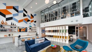 A spacious living area with a blue sofa, a coffee table, and a bookshelf. - Spectacular Apartments by BCA Furnished Apartments Spec1b 508 I (Atlanta)