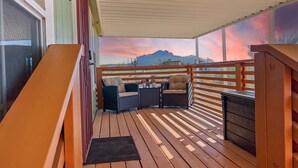 Eine Holterrasse mit Blick auf Berge und einen Sonnenuntergang.