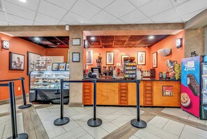 A bakery counter with a display case, a coffee machine, and a sign for Bunny Ice Cream. - Oceanfront Penthouse! Heated Indoor Waterpark! Dunes Village Resort (Myrtle Beach)