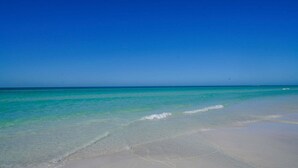 A beach with clear turquoise water and a sandy shore. - A Shell House Casa (Siesta Key)