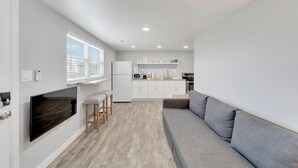 A modern kitchen with white cabinets, a built-in oven, and a large window. - 8820 Rocky Creek Drive Unit B (Tampa)