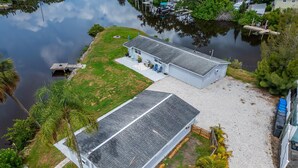 Een tweelaags huis met een ruime voortuin en een steiger die in het water uitloopt.