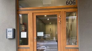 En trædør i dobbeltmodel med nummer 606 over døren, et glasfelt og et tastatur på venstre side.