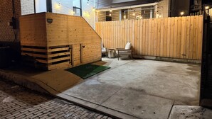 Una estructura de madera con una rampa, una zona cercada y un banco.